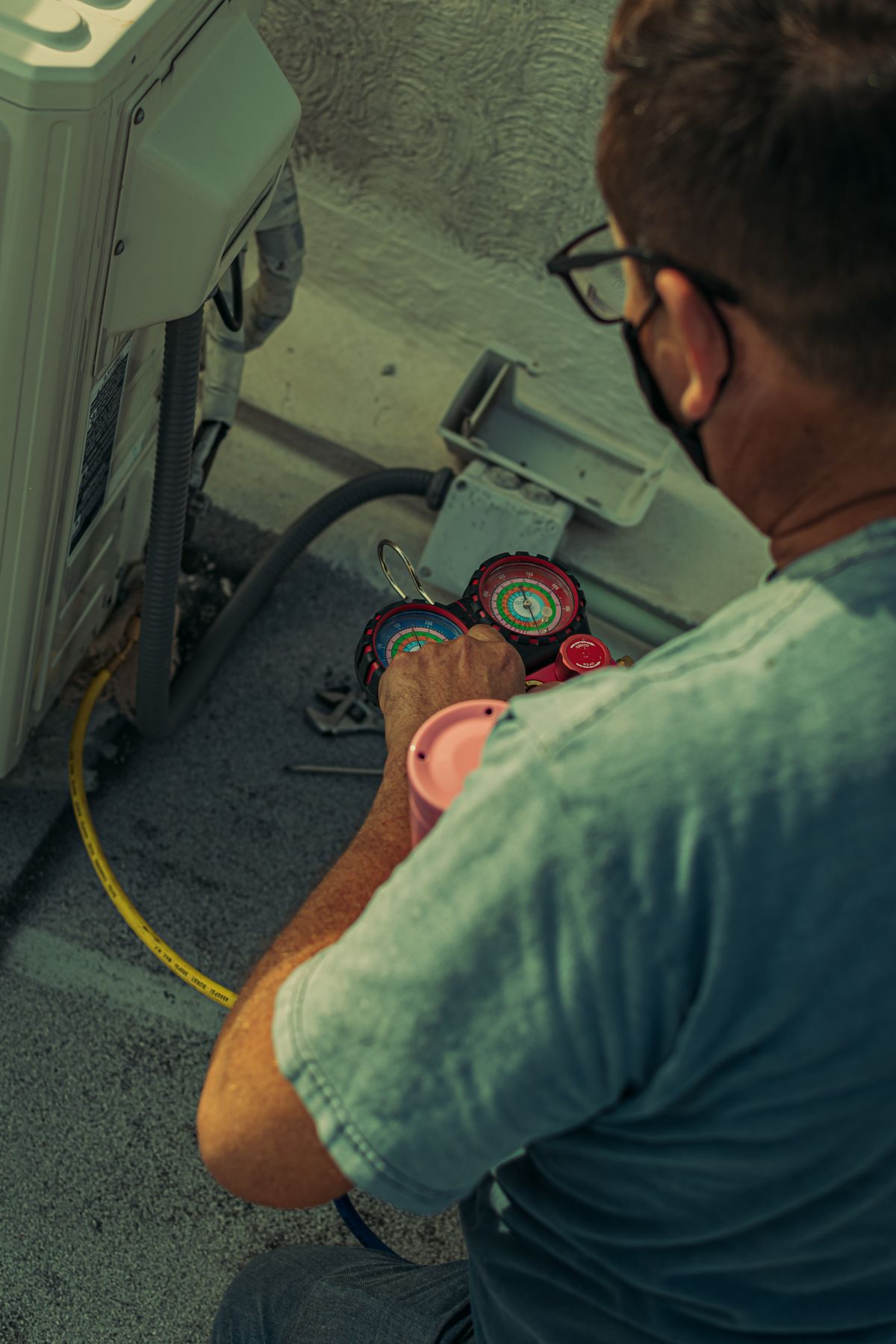HVAC technician checking refrigerant levels on an outdoor unit