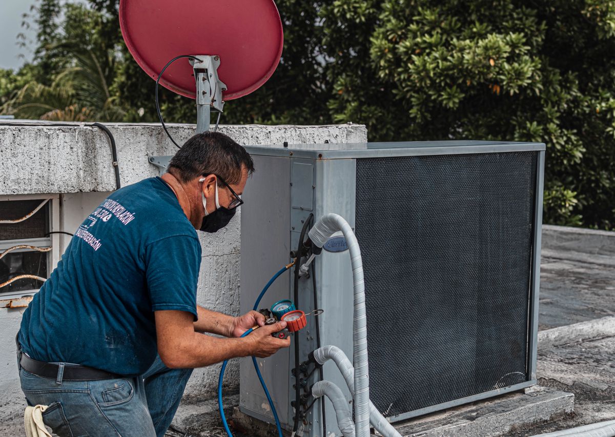 Technician servicing an outdoor air conditioning unit